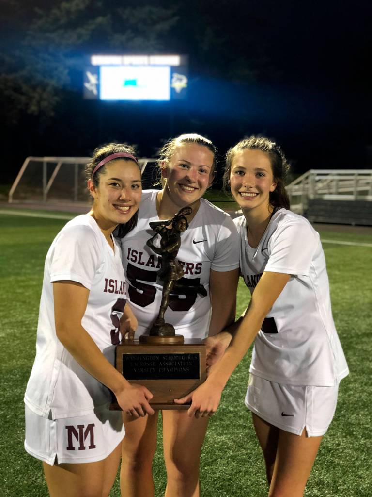 Mercer Island girls lacrosse players Grace Fujinaga, Annabelle Gersch and Hannah Tiscornia hold the state championship trophy following their 10-9 victory against Bainbridge Island in the Washington Schoolgirls Lacrosse Association championship game on May 17. Photo courtesy of Kathy Gersch