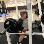 Mercer Island quarterback Clay Dippold completes a set of reps on the squat rack in the weight room on June 14. Shaun Scott/staff photo