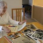 Linda Tammone, daughter of Wizard of Oz extra Meredythe Glass, looks through her mothers photographs, newspaper clippings, cards and memorabilia in Glasss former apartment at Covenant Shores on Sept. 5. Madison Miller / staff photo