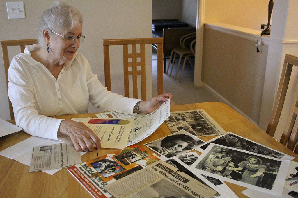 Linda Tammone, daughter of Wizard of Oz extra Meredythe Glass, looks through her mothers photographs, newspaper clippings, cards and memorabilia in Glasss former apartment at Covenant Shores on Sept. 5. Madison Miller / staff photo