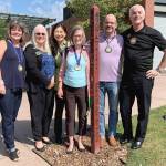 Mercer Island rotarians Beth Baska, Becca Palm, Soonok Kwak, Carol Friends, Steve DeVos and Brent Jordan standing with one of the islands 20 peace poles. Picture by Tracy Drinkwater