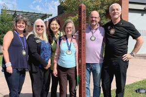Mercer Island rotarians Beth Baska, Becca Palm, Soonok Kwak, Carol Friends, Steve DeVos and Brent Jordan standing with one of the islands 20 peace poles. Picture by Tracy Drinkwater