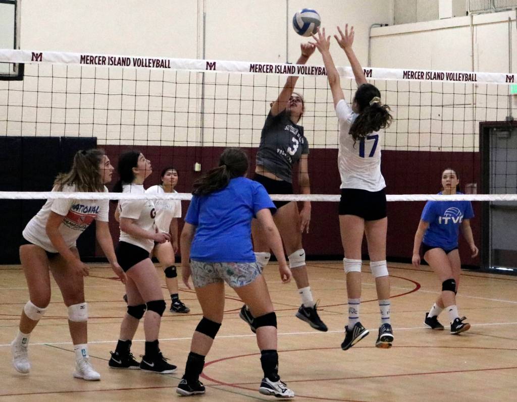Freshman Samantha Silke (grey No. 3) hits the ball over the net at a Mercer Island volleyball practice. Benjamin Olson/ staff photo