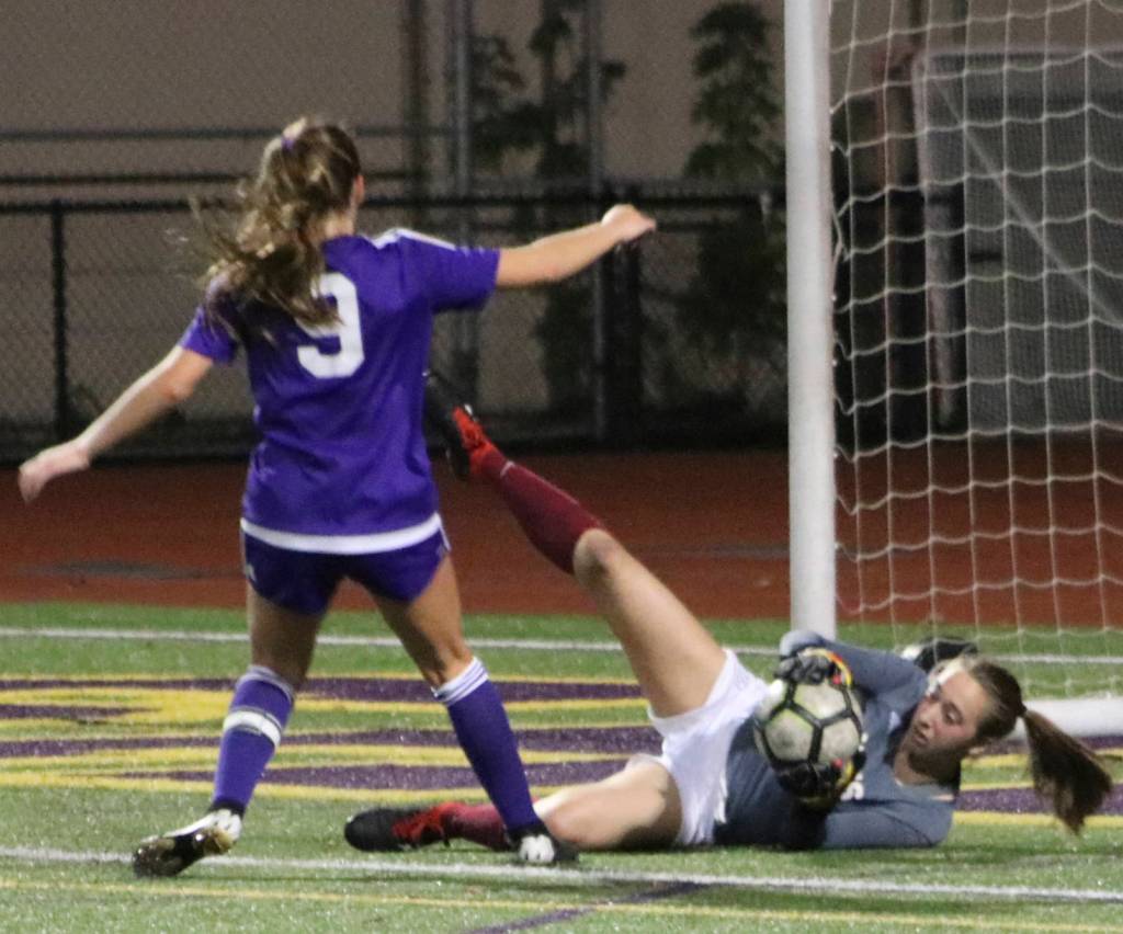 Mercer Island goalkeeper Amy Braman collects the ball from the feet of Issaquahs Jaden Humbyrd (#9) on Sept. 19. Benjamin Olson/ staff photo