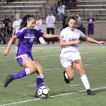 Islanders freshman Arden Paglia (in white) tries to take the ball off Eagles midfielder Kira Terao (in purple) during a 6-0 loss to Issaquah. Benjamin Olson/ staff photo