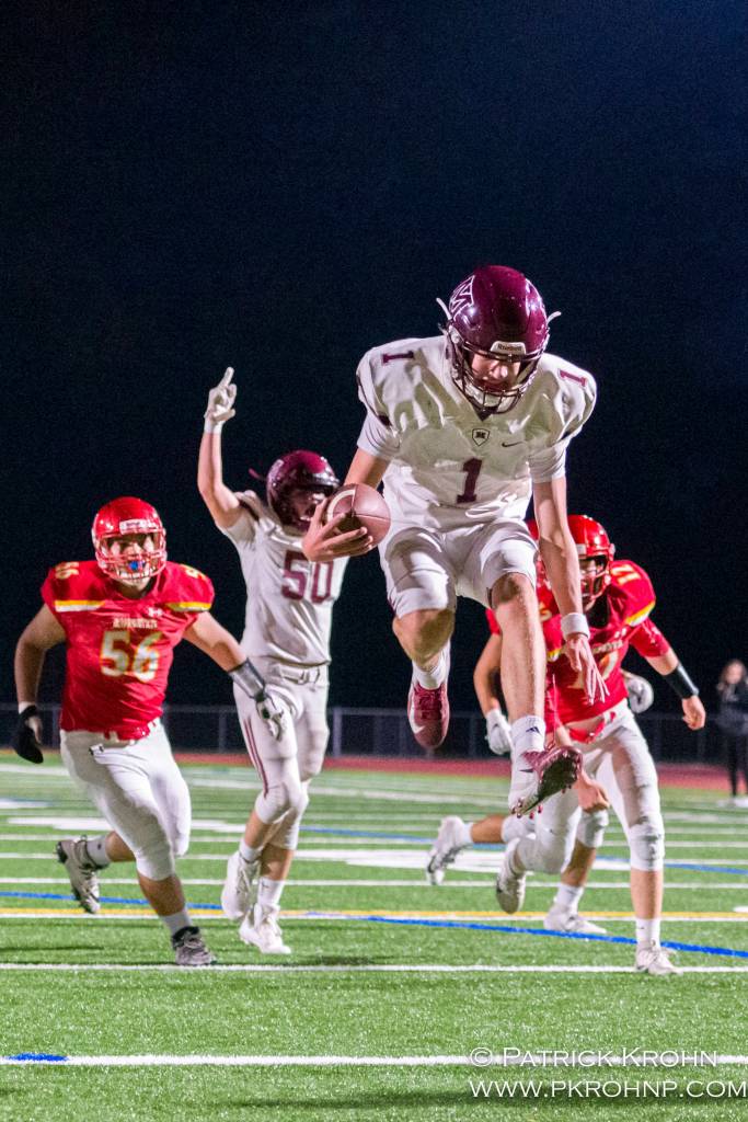 Mercer Island quarterback Liam Rogan leaps into the end zone in the second quarter of their 27-17 victory over the Newport Knights on Sept. 20. Photo courtesy of Patrick Krohn/Patrick Krohn Photography