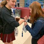 Bella Hartman draws orange hearts on Sophie Gottesmans hand for her refugee awareness day at MIHS on Nov. 15. Courtesy photo