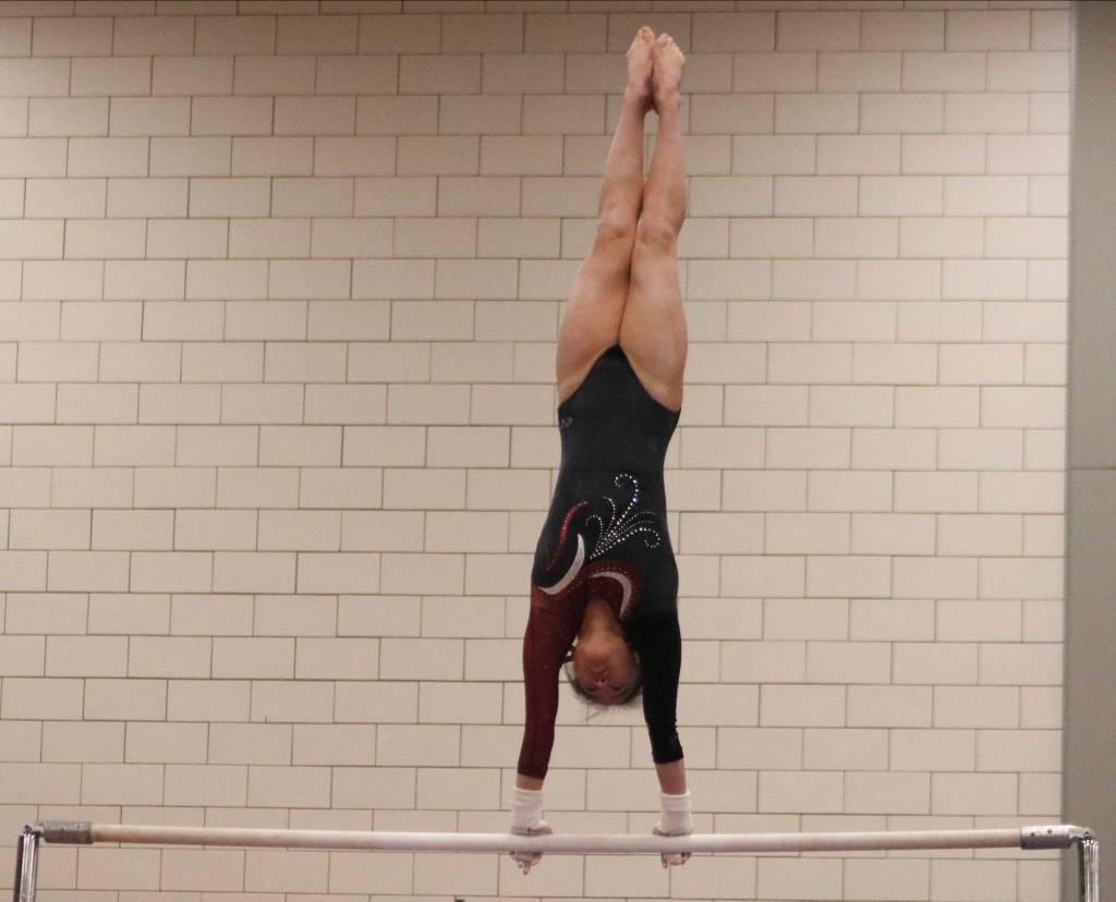 Mercer Island sophomore Rachel Ressmeyer performs giants on the bars. during a meet on Dec. 12, at Sammamish High School. Benjamin Olson/staff photo