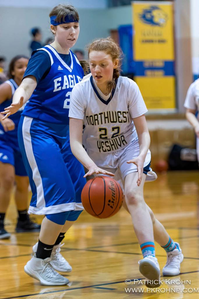 Northwest Yeshiva forward Eliana Menashe (right) dribbles the ball during the Lions basketball game against the Grace Academy Eagles on Dec. 14. Photo courtesy of Patrick Krohn/Patrick Krohn Photography
