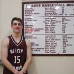 Luke Wenzel stands in front of the plaque in the Mercer Island gym that lists all the records for the boys basketball team. Wenzel tied the career record for defensive charges with 43 during the Islanders 47-31 victory over Sammamish on Jan. 7. Benjamin Olson/staff photo