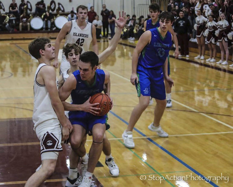 Luke Wenzel (left) attempts to draw a charge against the Liberty Patriots on Dec. 10. Wenzel has drawn 18 charges this season, eight away from the single-season record of 26 (Mike Ginn 1973-74). Photo courtesy of Don Borin/Stop Action Photography