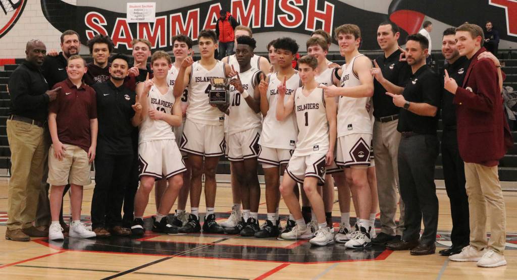 The Mercer Island boys basketball team celebrates its 61-36 victory over Interlake in the 3A KingCo championship game on Feb. 11 at Sammamish High School. Benjamin Olson/staff photo