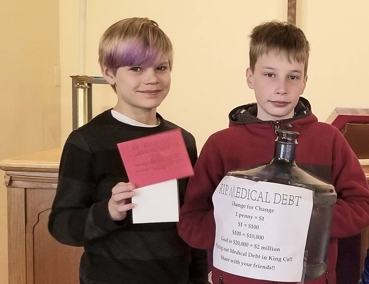 Courtesy photo                                Brody Newcomer (left) and Matthew Duffie, two Sunday school children at Holy Trinity Lutheran Church on Mercer Island, pose with a change collection bank for the churchs Lent fundraiser with RIP Medical Debt.