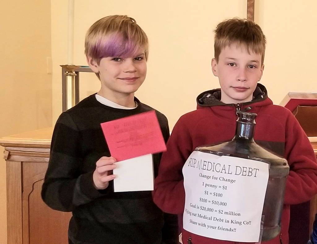 Courtesy photo                                Brody Newcomer (left) and Matthew Duffie, two Sunday school children at Holy Trinity Lutheran Church on Mercer Island, pose with a change collection bank for the churchs Lent fundraiser with RIP Medical Debt.