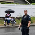 A police officer standing by as a family looks on. Blake Peterson/staff photo