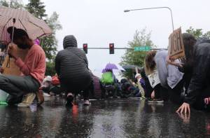 Protestors kneeling in silence at the intersection of Island Crest Way and Southeast 40th Street. The gesture lasted eight minutes and 46 seconds  the amount of time white Minneapolis Police Officer Derek Chauvin knelt on George Floyds neck. Staff photo/Blake Peterson