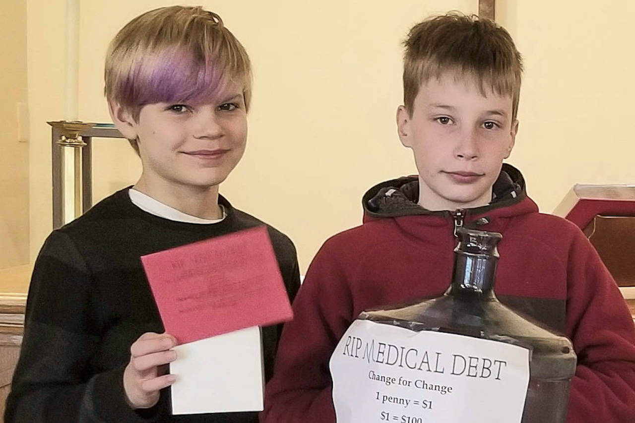 Brody Newcomer (left) and Matthew Duffie, two Sunday school children at Holy Trinity Lutheran Church on Mercer Island, pose with a change collection bank for the churchs Lent fundraiser with RIP Medical Debt earlier this year. The churchs youths, according to director of Intergenerational Ministry Programs Kathy Fisher, were integral to fundraising efforts. Photo courtesy HTLC