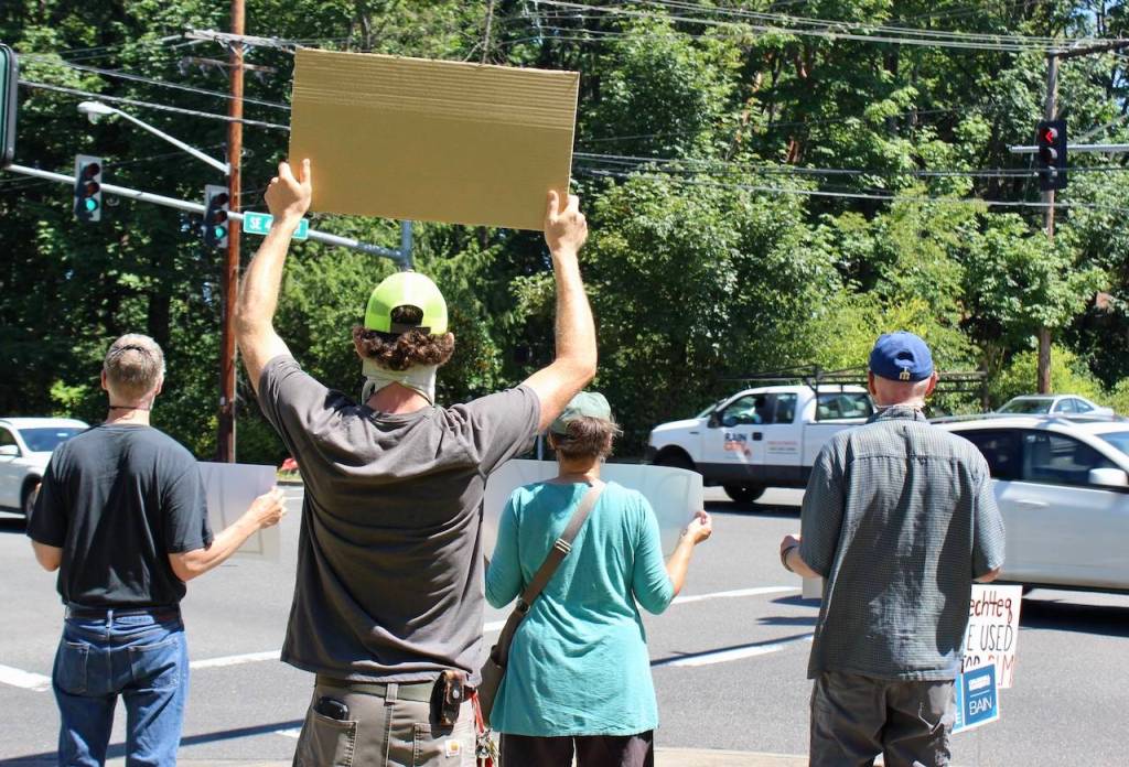 Signs held up at the protest reminded onlookers that Racism is a Pandemic. Blake Peterson/staff photo