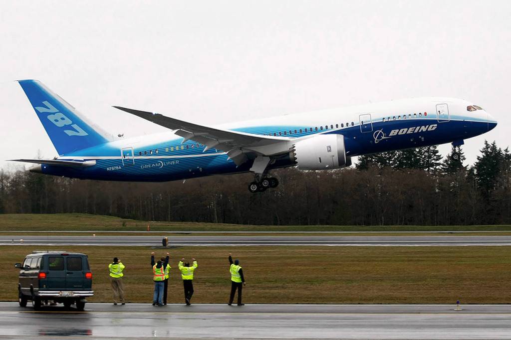 Workers cheer and wave as Boeings 787 Dreamliner takes off from Paine Field on Dec. 15, 2009. (Justin Best/ Herald file)