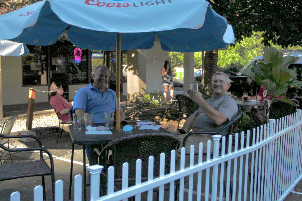 Federal Way residents Kevin Jochim, left, and Steve Reichel enjoy drinks on the new patio area at JPs Tavern on Aug. 5. File photo