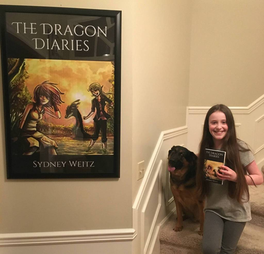 Sydney Weitz displays her book, The Dragon Diaries, alongside her dog, Jäger. Courtesy photo