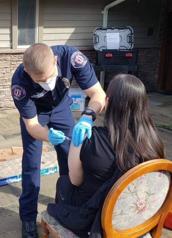 Emergency medical technician Tommy Edwards administers a COVID-19 vaccine dose to a Twilight Adult Family Homes resident on March 8. Photo courtesy of the Mercer Island Fire Department