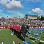 Graduates stroll to their seats. Andy Nystrom/ staff photo