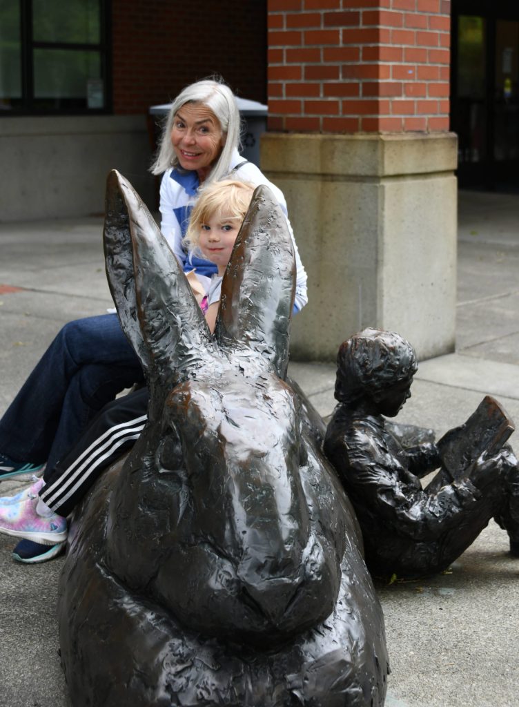 Linda Lisbakken sits with her granddaughter, Berrit Martz, 4, prior to the reopening of the Mercer Island Library on July 7. They were excitedly waiting for the doors to open while partaking in their lunch on the librarys signature rabbit statue. The library  located at 4400 88th Ave. SE  had been closed since March of 2020 when the COVID-19 pandemic hit. Doors will be open from 1-8 p.m. Tuesdays and Wednesdays and from 10 a.m. to 5 p.m. Thursdays, Fridays and Saturdays. Andy Nystrom/ staff photo