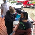 Nurse Sara Hardin, part of Puget Sound Fires first COVID-19 mobile vaccination unit, delivers a shot Jan. 21 to a resident at an adult family home in Kent. Kyle Waterman, a King County Medic One paramedic, looks on. COURTESY PHOTO, Puget Sound Fire