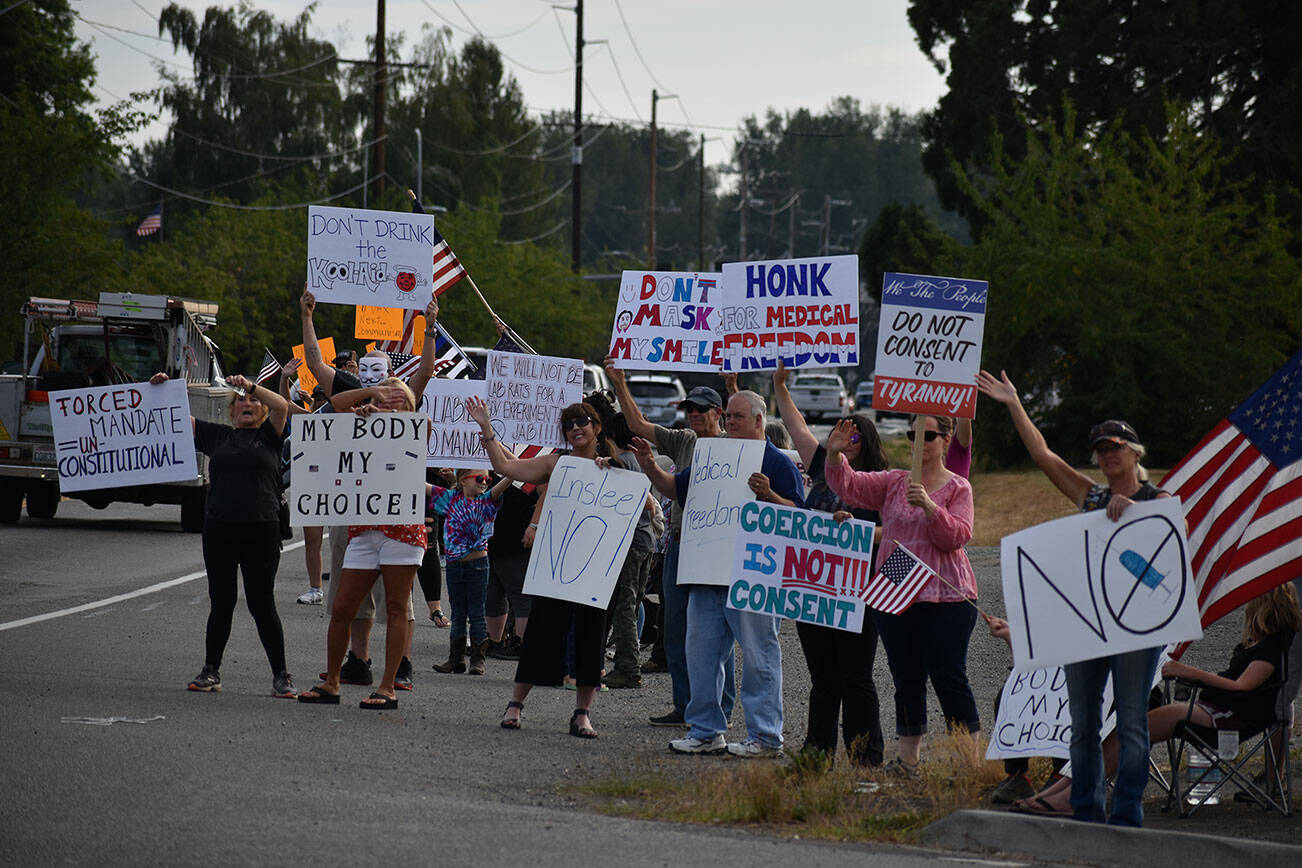 People hold up signs in protest of Gov. Jay Inslees latest proclamations during a Rally for Medical Freedom on Aug. 25 in Buckley. Photo by Alex Bruell/Sound Publishing