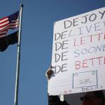 Postal worker hold sign criticizing Postmaster Louis DeJoy (photo credit: Cameron Sheppard)