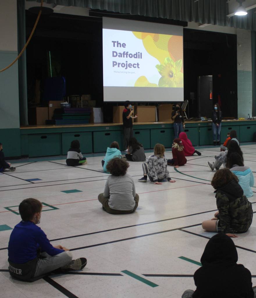 Island Park Elementary School students watch a presentation about the Worldwide Daffodil Project by the Mercer Island High School Holocaust Education Committee. Andy Nystrom/ staff photo