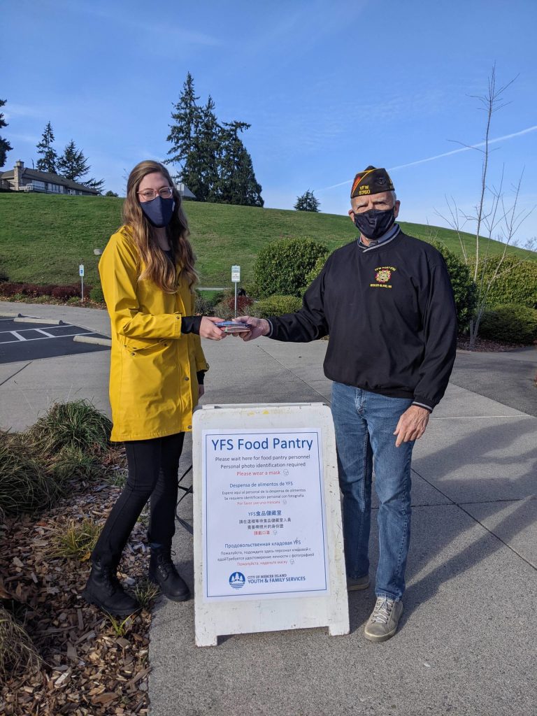 Mercer Island VFW Post 5760 representative Robert Harper presents Marina Gonzales with $1,000 worth of QFC food gift cards for distribution through the Mercer Island Youth and Family Services food pantry. Photo courtesy of Tambi Cork