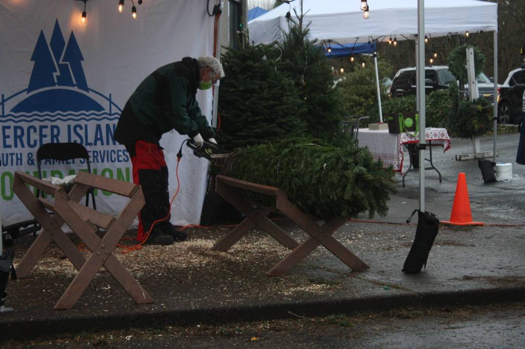 Don Kovarik trims a tree at the Mercer Island Youth and Family Services (YFS) Foundation tree lot on Dec. 2. The lot  located at the old Tullys parking lot at 7810 SE 27th St. - will be open through Dec. 12 on Thursdays (3-7 p.m.), Fridays (3-7 p.m.), Saturdays (10 a.m. to 5 p.m.) and Sundays (10 a.m. to 5 p.m.). All the proceeds from sales support YFS programs. Andy Nystrom/ staff photo