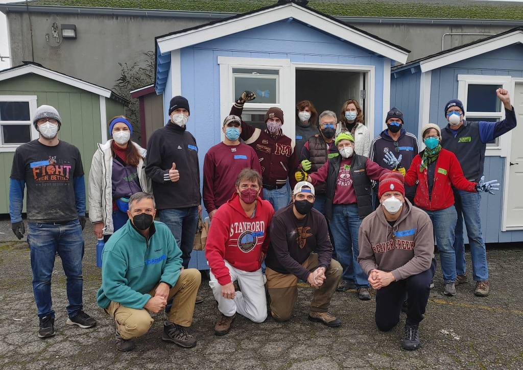 A group of volunteers, including Mercer Islanders, stand in front of a tiny house constructed by Amazon Web Services employees and others. Andy Nystrom/ staff photo