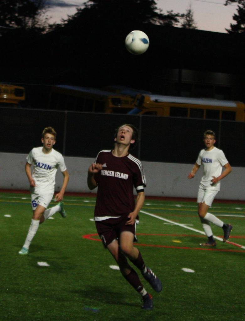 Mercer Islands Brady Gilroy heads the ball as a pair of Highlanders watch from behind. Andy Nystrom/ staff photo