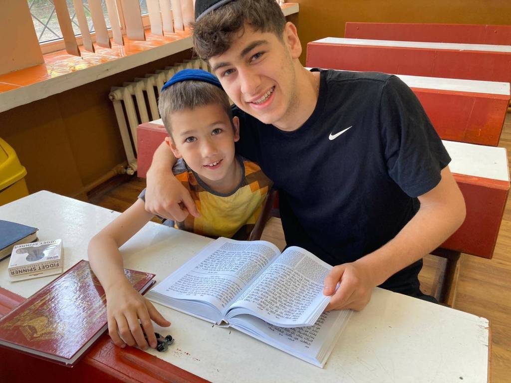 Northwest Yeshiva High School senior Yoel Kintzer reads with a Ukrainian orphan in Neptun, Romania. Courtesy photo