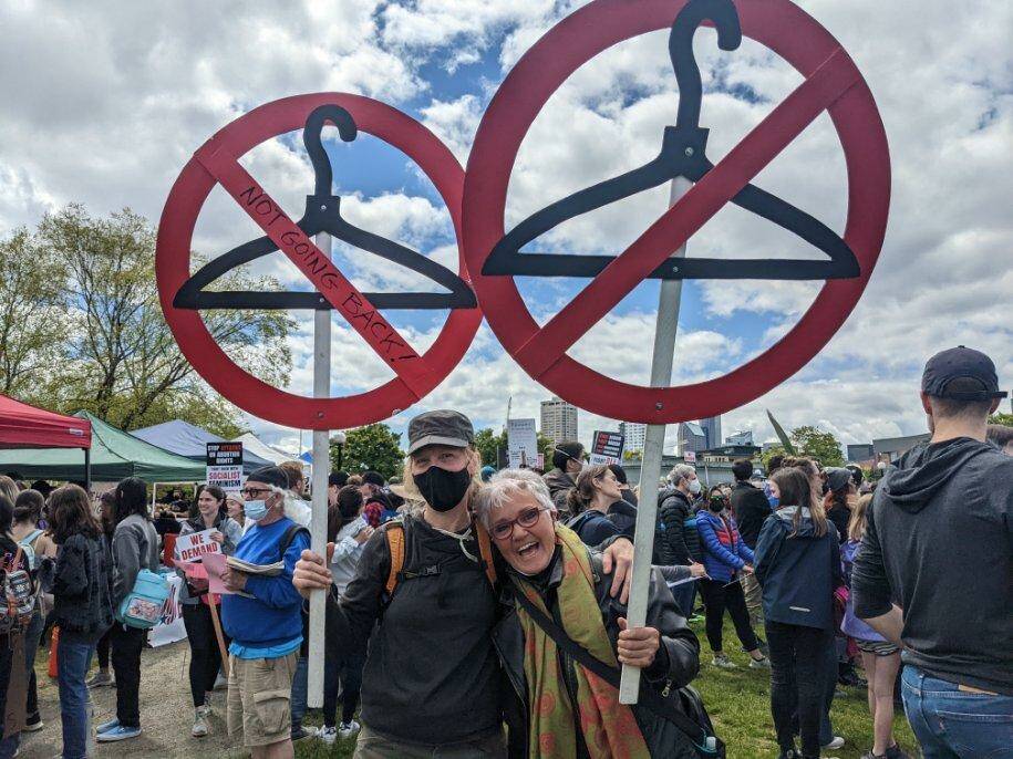Two people stand with coathanger signs at the reproductive rights protest on May 14, 2022 at Cal Anderson Park. Hannah Saunders/Sound Publishing