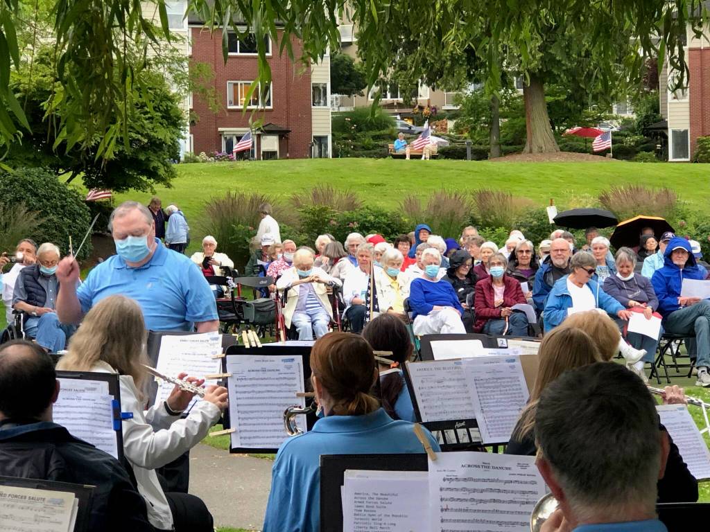 Despite on and off again rain showers, residents of Covenant Living at the Shores on Mercer Island enjoyed an outdoor patriotic concert performed by the Bellevue Community Band on July 5 to celebrate the nations independence. This was the bands first concert since March of 2020 when the pandemic hit. The performance took place near a historic 110-year-old willow tree on the lakeshore of the senior living community. It was just four years ago when the tree collapsed following the bands performance. It has since grown back from what was just an eight-foot stump to its previous size. Courtesy photo