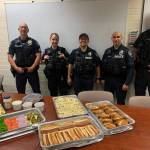 From left to right, Mercer Island Police Departments sergeant Dominic Amici, officer Jacqueline Dawson, officer Luis Paz, officer Art Munoz and sergeant Scott Schroeder receive a Fourth of July lunch from thankful residents. Eleven officers were on duty that day, including three Marine Patrol units on the water. Photo courtesy of corporal Bobby Jira