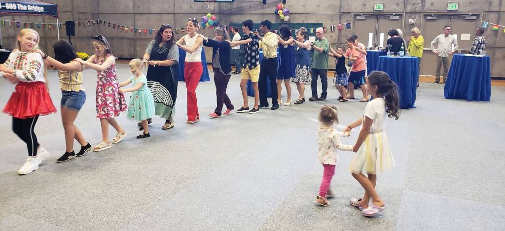 Attendees at the Rotary Club of Mercer Islands International Dance for Peace form a spontaneous conga line while children dance to live world music on Sept. 18 at the Mercer Island Community and Event Center. The event, which drew about 300 people and was billed as an All Island Dance Party, raised a significant amount of money to support international grants and humanitarian aid, including ones for Ukraine. Multiple Ukrainians who live on Mercer Island attended the event and met each other. The event replaced the Rotary half marathon, which had to be canceled due to COVID, and featured world music, a homemade-cookie table, a Drum Roll wine bar and multigenerational attendees from children to grandparents. The amount raised was not available at press time. To donate, visit <a href="http://www.mirotarydance.org" target="_blank">www.</a><a href="http://www.mirotarydance.org" target="_blank">mirotarydance.org</a>. Photo courtesy of John Hamer