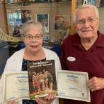 Denny and Sharon Horn, Mercer Island residents, hold certificates and an official program from the Seattle Mariners first home game in 1977, played in the Kingdome. The Horns are among the growing crowd of fan hopefuls cheering the Mariners chances of making postseason play. They watched with pride as Mercer Islander Matt Boyd get his first win as a Mariners pitcher last week. The Horn family and Boyd family are longtime members of Evergreen Covenant Church on the island. Courtesy photo
