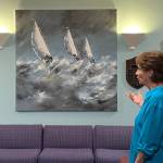 Jane Meyer Brahm of the Mercer Island Sister City Association discusses a painting displayed in city hall that Mercer Island received from its sister city, Thonon-les-Bains in France. Photo courtesy of the city of Mercer Island