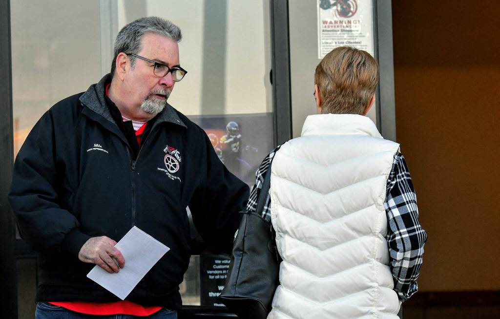 Mike Raughter, a union representative with the Marysville Albertsons, hands a leaflet to a shopper during an informational campaign on Wednesday. Raughter was one of less than a dozen grocery store workers handing out leaflets to shoppers about the proposed merger between Albertsons and Kroger. (Mike Henneke / The Herald)
