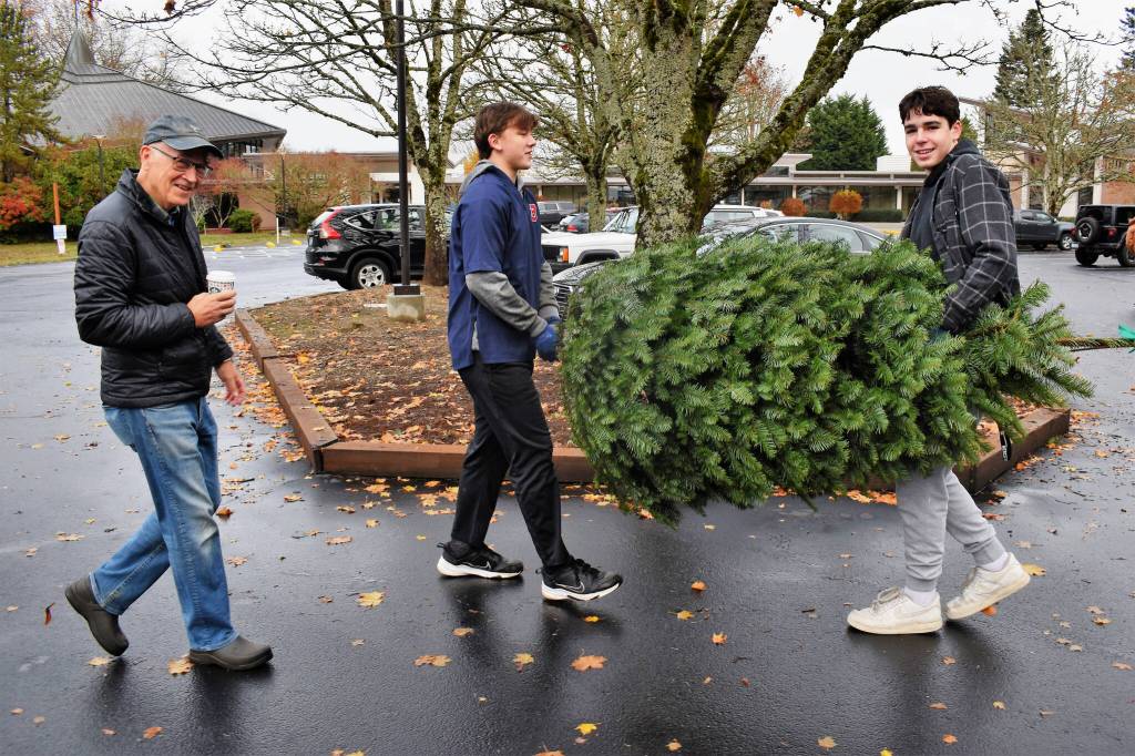 Evan Otte and Sam Dilworth carry a tree to a car at the Mercer Island Community Holiday Tree Lot on Nov. 26. Photo courtesy of Kym Otte