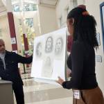 Artist Al Doggett is joined by Michelle Flowers-Taylor, board chair of the Stanley Ann Dunham Scholarship Fund, on Nov. 29 in describing his technique in drawing a portrait of Dr. Dunham that hangs (at right) in the foyer at Mercer Island High School. Andy Nystrom/ staff photo