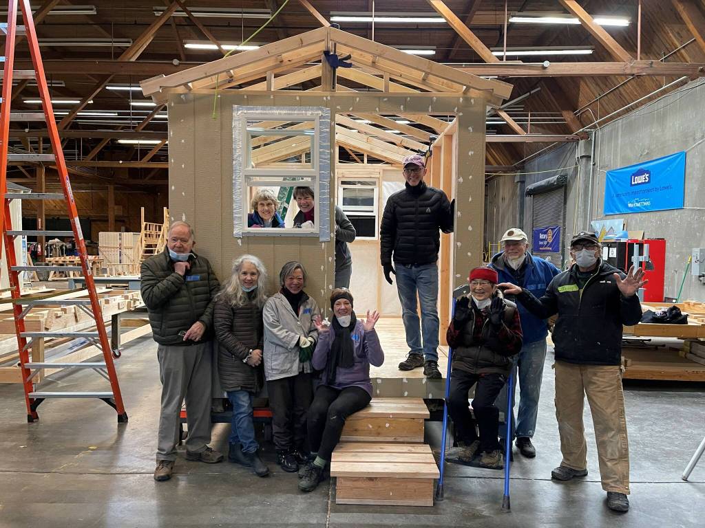 Pictured Mercer Island Rotarians at a tiny houses for the homeless building event in Seattle last year are Bunnie Cundiff (sitting on stairs); Edie Warner (in window to the right); Mike Finn (standing, second from right); and Terry Lee (farthest right). Courtesy photo