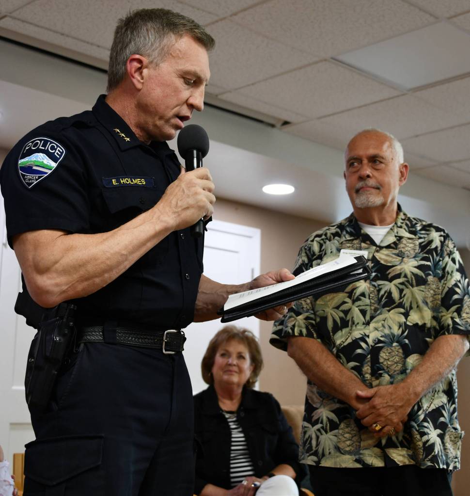Mercer Island Police Department Chief Ed Holmes reads a poem for Greg Asimakoupoulos, whose wife Wendy looks on. Andy Nystrom/ staff photo
