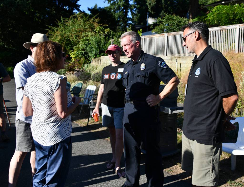Mayor Salim Nice and Mercer Island Police Department Chief Ed Holmes, from right to left, engage in conversation with Islanders at a National Night Out event at Tana Senns home. Andy Nystrom/ staff photo