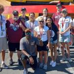KMIH 889 The Bridge Log Boom Radios three-day broadcast over Seafair Weekend Festival was a resounding success as the student staff tapped into all the live action from the Stan Sayers pits from Aug. 4-6. From left to right: Mercer Island High School (MIHS) video teacher Michael Ketchum, broadcasting teacher Joe Bryant, rising junior Toly Odievich, rising senior Melena Wong, rising senior Sophie Cartwright, broadcasting teacher Natalie Woods, rising sophomore Aadyaa Singhal, rising sophomore Will Prock, rising sophomore Alexandra Foss and rising senior Elise McDonald. Pictured in front is H1 hydro driver and MIHS alum Brent Hall. This year, Seafair had bigger crowds and better quality racing than I have seen in years. Our Log Boom Radio broadcast coverage was also stepped up. Thanks to the great job our students have done in past years, Seafair set us up in a prime spot in the hydro pits with easy access to interview the drivers, pilots, clowns, pirates and everything that makes Seafair great, Bryant said. Photo courtesy of the Mercer Island School District
